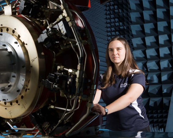 A photograph of a DSTG researcher checking Servo valve voltages on the Flight Motion Simulator as part of the pre-trial checks before a Hardware-in-the-Loop simulated flight engagement.