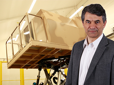 Eugene Aidman in front of the DST Land Motion Platform vehicle simulator. Eugene Aidman in front of the DST Land Motion Platform vehicle simulator