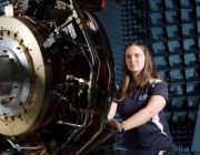 A photograph of a DSTG researcher checking Servo valve voltages on the Flight Motion Simulator as part of the pre-trial checks before a Hardware-in-the-Loop simulated flight engagement.